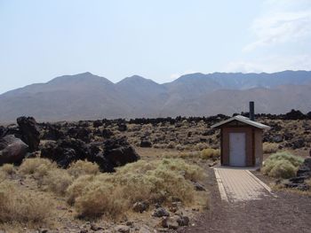 Built structure on field by mountains against sky