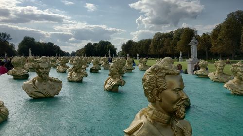 Statue by river against sky