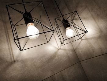 High angle view of illuminated light bulb hanging on ceiling