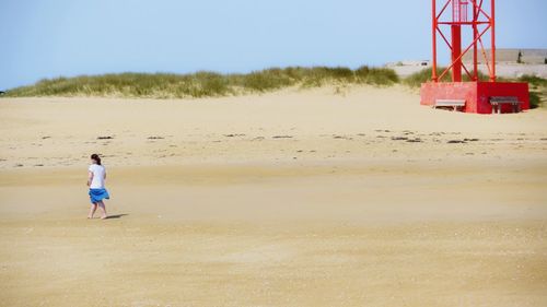 Man standing on beach against clear sky