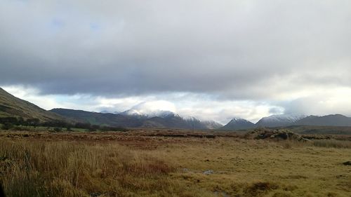 Scenic view of landscape against storm clouds