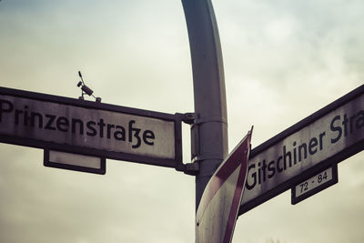 Low angle view of road sign against sky