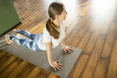 High angle view of woman lying on hardwood floor at home