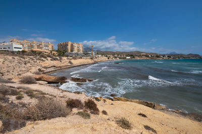 Scenic view of beach against blue sky