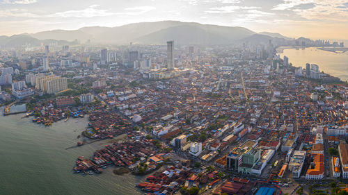 High angle view of city by sea against sky