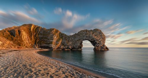 Scenic view of rocks on sea against sky