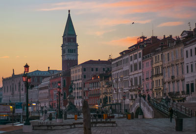 Buildings in city at sunset