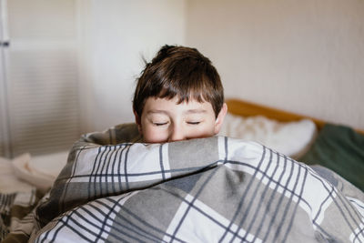 Portrait of boy relaxing on bed at home