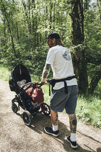 Man walking in forest with baby stroller