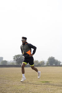 Rear view of man exercising on field