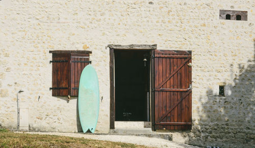 Surfboard by open door in town