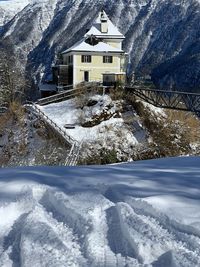 Snow covered houses by buildings against mountain in hallstatt austria 