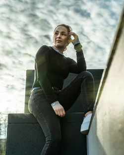 Young woman looking away while sitting outdoors