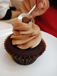 Close-up of hand holding chocolate cake