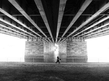 Person walking under bridge in city