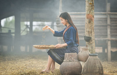Young woman cleaning grains on field