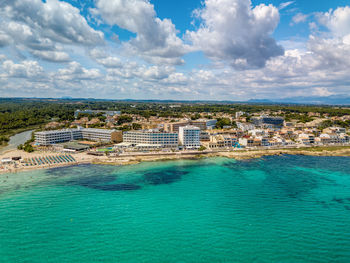 High angle view of townscape by sea against sky