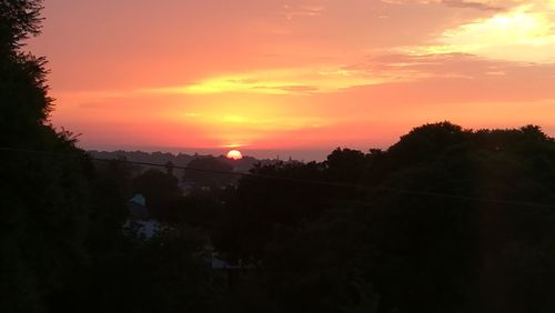 Scenic view of silhouette landscape against orange sky