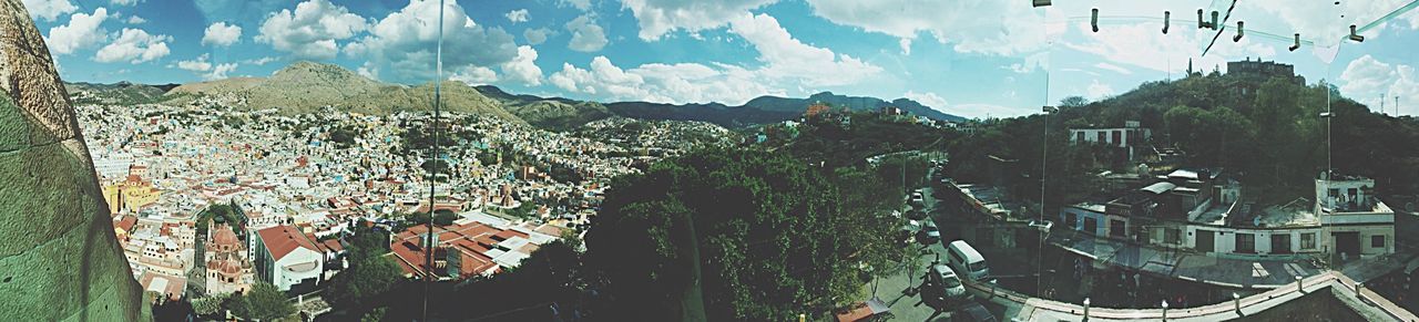 mountain, sky, mountain range, building exterior, built structure, architecture, panoramic, house, nature, beauty in nature, cloud - sky, sunlight, tranquility, scenics, tree, tranquil scene, landscape, cloud, day, outdoors