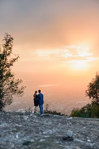 Rear view of man standing against orange sky