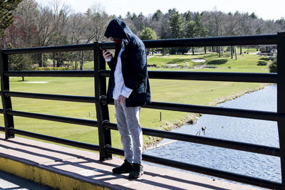 Side view of man standing by railing