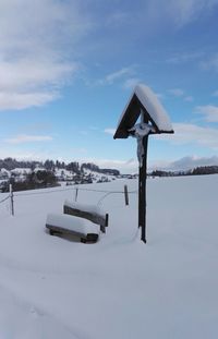 Scenic view of snow covered field against sky