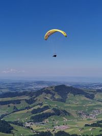 Aerial view of people paragliding against sky