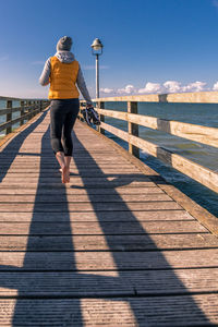 Barefoot woman walking on a bridge