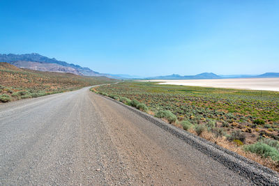 Scenic view of road amidst land against sky