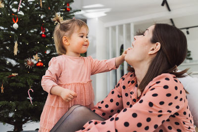 Side view of mother and daughter at home