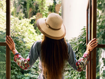 Rear view of woman wearing hat standing outdoors