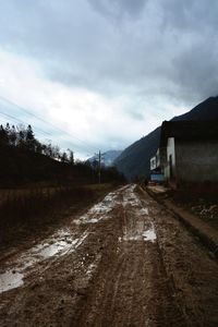 View of country road against cloudy sky