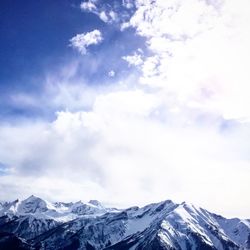 Low angle view of snowcapped mountains against sky