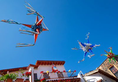 Low angle view of traditional windmill against clear blue sky