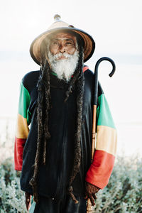 Portrait of old rastafari with dreadlocks looking at the camera in the nature with white background