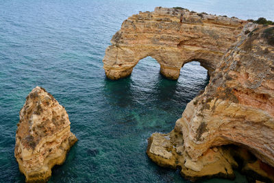 Rock formation in sea against sky