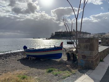 Boats moored on beach against sky