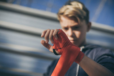 Low angle view of boy wearing red strap while standing outdoors