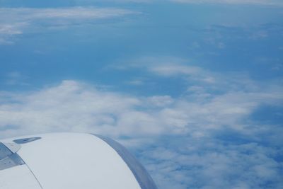 Airplane flying over clouds against blue sky