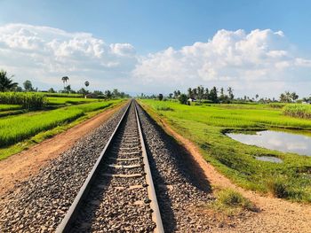 Diminishing perspective of railroad track against sky