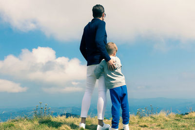 Full length of father with daughter standing against sky