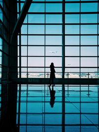Silhouette woman standing at airport terminal 