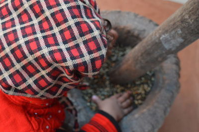 High angle view of baby girl sitting by stone bowl