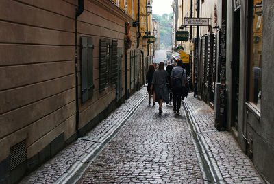 Rear view of people walking on footpath