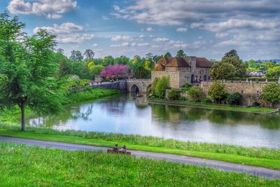 Scenic view of lake by buildings against sky
