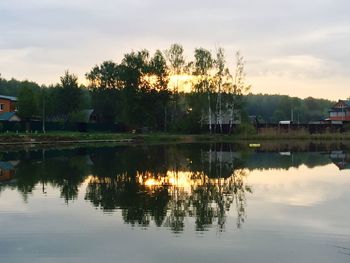 Reflection of trees in lake against sky during sunset