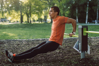 Man doing push-ups on railing at park