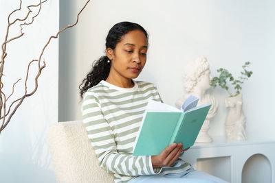 Portrait of smiling young woman using laptop at home