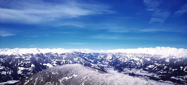 Scenic view of snowcapped mountains against blue sky