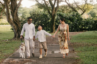 Rear view of woman standing against trees